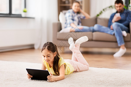 童,技术家庭小女孩平板电脑躺家里的地板上家里平板电脑的女孩躺地板上图片