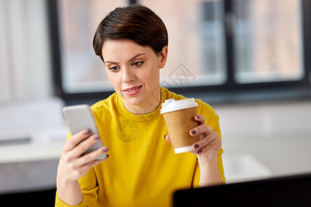 商业技术通信人的女商人打电话给智能手机,办公室用纸杯喝外卖咖啡办公室打电话给智能手机的女商人图片