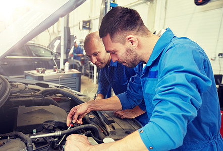 汽车服务,维修,维护人的技工与扳手修理汽车车间车间用扳手修理汽车的机械工人图片