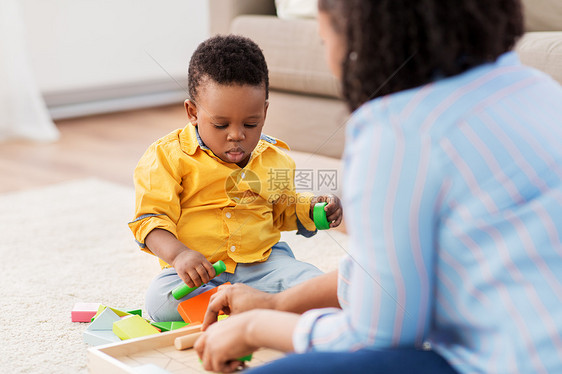 童,孩子人的非裔美国母亲她的小儿子玩木制玩具积木套件地板上家里妈妈宝宝家玩玩具积木图片
