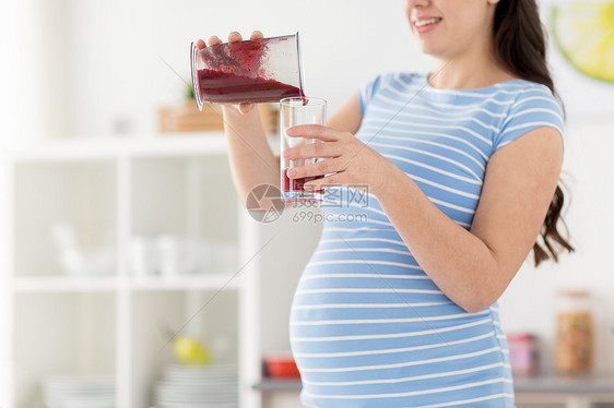 健康的饮食,烹饪怀孕孕妇倒水果冰沙搅拌机杯璃家厨房孕妇家倒水果奶昔图片