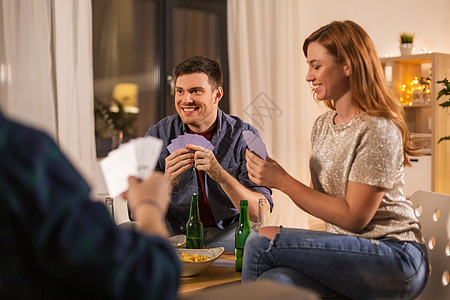 友谊休闲娱乐活动的快乐的朋友家里玩纸牌游戏晚上喝啤酒朋友家打牌喝啤酒图片