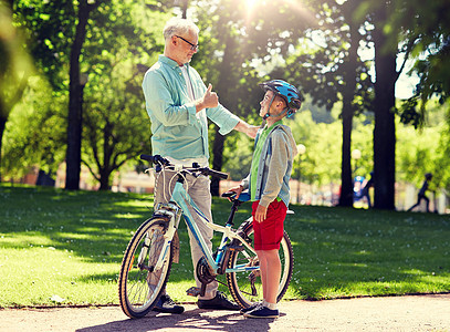 家庭,世代,安全人的快乐的祖父男孩,自行车自行车头盔夏季公园祖父男孩夏季公园骑自行车图片
