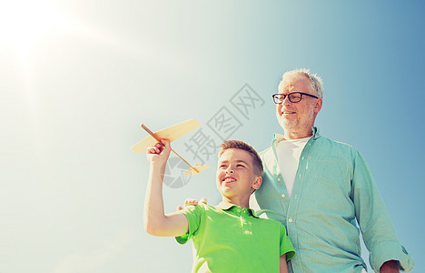 家庭,代,未来,梦想人的快乐的祖父孙子,玩具飞机蓝天上老人男孩带着玩具飞机飞过天空图片