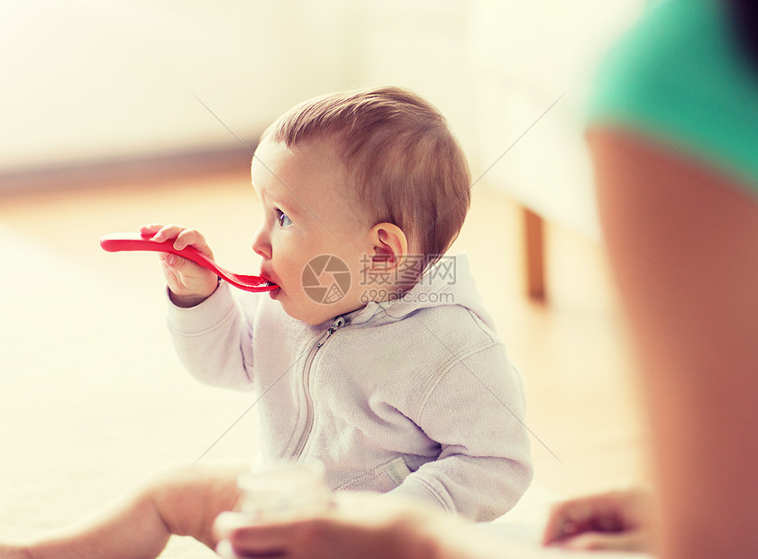 母亲喂养婴儿用勺子吃饭图片