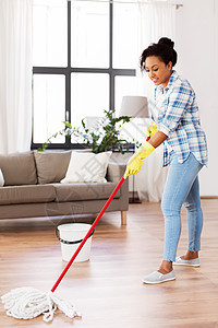 家务家务非裔美国妇女家庭主妇与拖把清洁地板家里非洲妇女家庭主妇家清洁地板图片