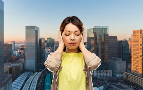 人,情感压力的亚洲轻妇女耳朵手东京城市背景亚洲女人东京城用手闭着耳朵图片