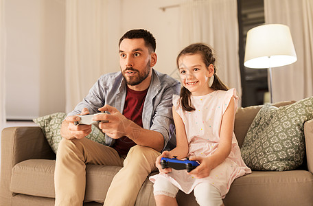 家庭,游戏娱乐活动快乐的父亲小女儿家里玩电子游戏父亲女儿家玩电子游戏图片