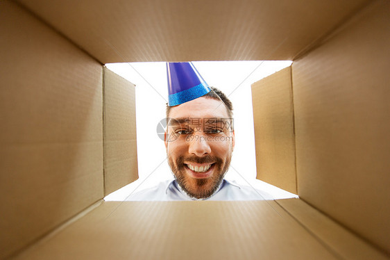 礼物,送货惊喜快乐的人戴着派帽,看着打开的包裹盒生日礼物,下快乐的人打开包裹盒生日礼物图片