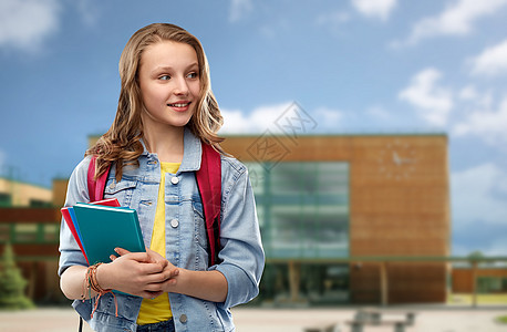 教育人的快乐微笑的十几岁的学生女孩带着书包书本学校背景下带着书包的快乐微笑的十几岁的学生女孩图片