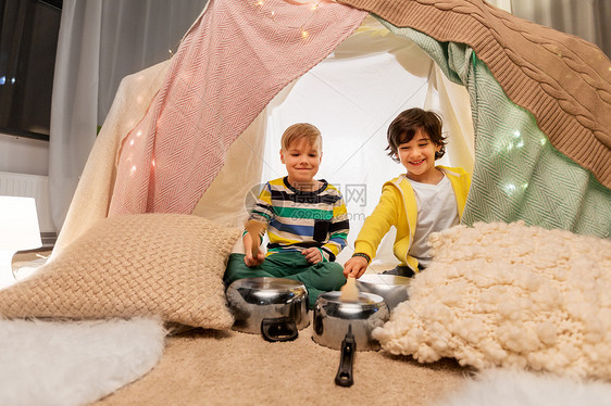 童潮湿的快乐的小男孩与烹饪锅播放音乐孩子帐篷家里孩子们家里的帐篷里着罐子放音乐图片