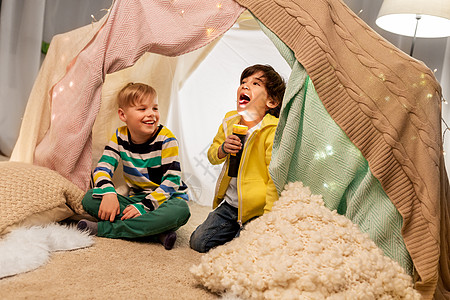 童,潮湿友谊的快乐的男孩与火炬光孩子帐篷帐篷家里玩快乐的男孩孩子们的帐篷里放着手电筒图片
