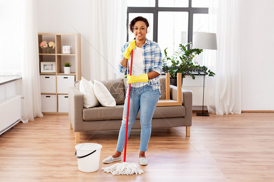 家务家务非裔美国妇女家庭主妇耳机清洁地板与拖把家里非洲妇女家庭主妇家清洁地板图片