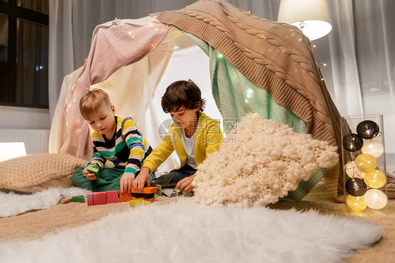 童,潮湿友谊的男孩玩玩具块孩子帐篷帐篷家里男孩家孩子们的帐篷里玩玩具块图片