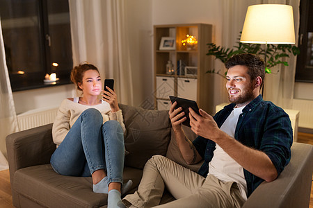 休闲,技术网络成瘾的夫妇与平板电脑智能手机家里晚上家里平板电脑智能手机图片