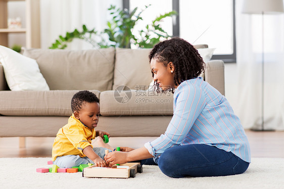 童,孩子人的快乐的非裔美国母亲她的小儿子玩木制玩具积木套件地板上家里妈妈宝宝家玩玩具积木图片