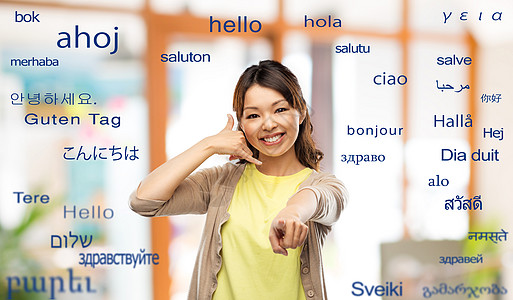 翻译,交流人的快乐的亚洲轻妇女打电话手势,并指着你用同的外语问候语女人用外来语电话手势图片