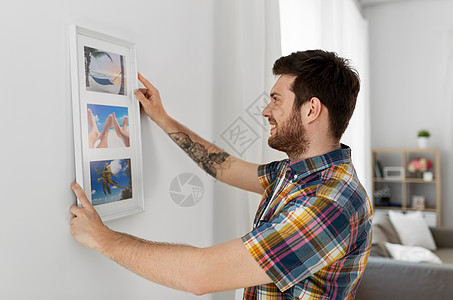 室内装饰翻新微笑的人挂框架墙壁家里男人家里把照片挂相框里挂墙上背景图片