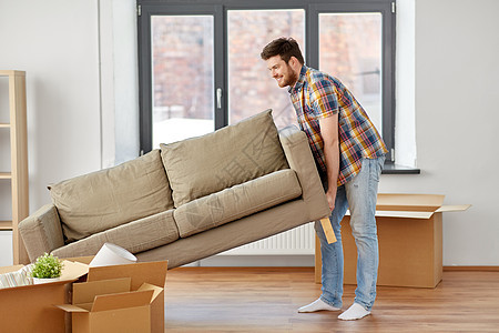搬家,人房地产的快乐的男人拖沙发新家快乐的人新家搬沙发图片