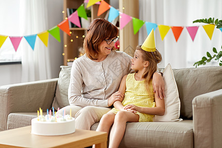 家庭,世代庆祝快乐的祖母孙女戴着生日蛋糕家的派帽祖母孙女带着生日蛋糕图片