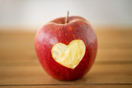 水果,食物健康成熟的红色苹果,雕刻心形木制桌子上木桌上雕刻心形的红苹果图片