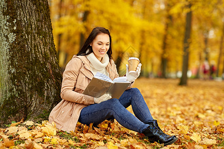 季节,技术人的轻的女人阅读书籍喝外卖咖啡纸杯秋季公园秋天公园里的女人用咖啡读书背景图片