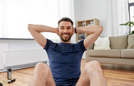 运动,健身健康的生活方式微笑的男人家腹部运动微笑的男人家腹部运动图片