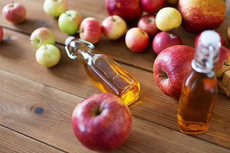 水果饮料季节璃瓶的苹果汁,苹果酒醋木制桌子上木制桌子上的苹果汁醋瓶图片