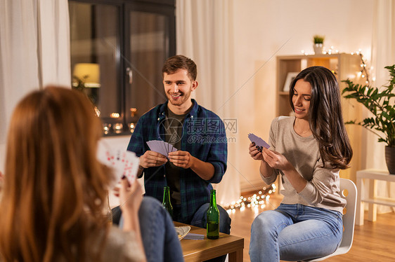 友谊休闲娱乐活动的快乐的朋友家里玩纸牌游戏晚上喝啤酒朋友家打牌喝啤酒图片