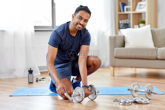 健身,运动,举重健美微笑的印度男子装哑铃家微笑的印度男人家里装哑铃图片