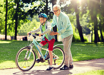 祖父男孩夏季公园骑自行车图片