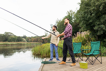 休闲人的男朋友与钓鱼竿湖墩湖墩上钓竿的男朋友图片