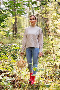 季节休闲的人的轻的女人带着蘑菇柳条篮子里走森林里女人带着篮子森林里采蘑菇图片