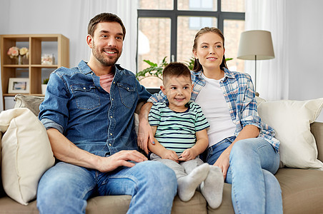 家庭,童父亲的幸福的父亲,母亲小儿子坐家里的沙发上的肖像幸福家庭坐家里沙发上的肖像图片