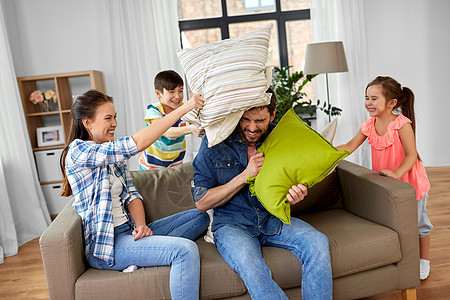 家庭,童人的快乐的父亲,母亲,小儿子女儿靠枕头打架,家里玩得开心幸福的家庭家里枕头大战图片