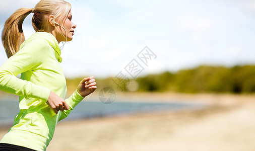 健身,运动健康的生活方式妇女与耳机运行听音乐夏季海滩背景耳机的女人公园跑图片