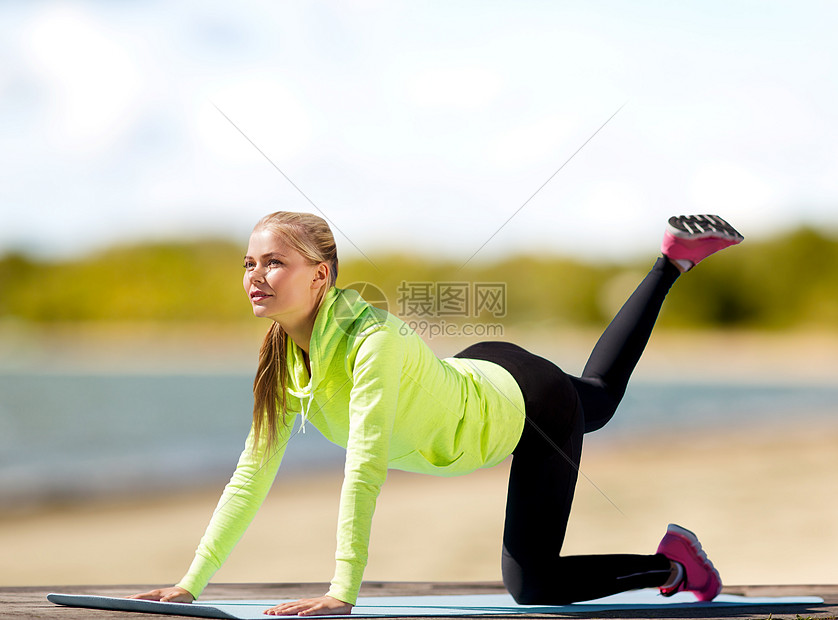 健身,运动健康的生活方式妇女夏季海滩背景下的运动垫培训海滩上锻炼垫子上的女人训练图片