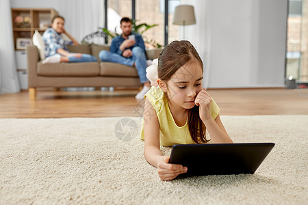 童,技术家庭小女孩平板电脑躺家里的地板上家里平板电脑的女孩躺地板上图片