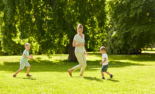 家庭休闲人的快乐的母亲两个小儿子夏季公园跑步玩接球游戏妈妈儿子夏天公园玩接球游戏图片
