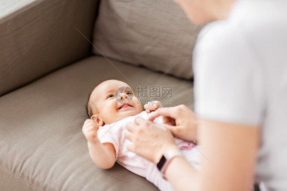 家庭,父母母亲的亲密的母亲玩小女儿躺沙发上家亲密的母亲家里婴儿玩耍图片