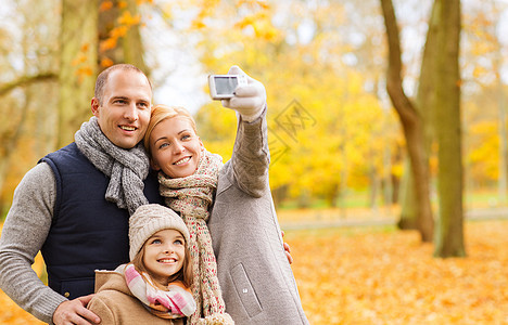 家庭,童,季节,技术人的快乐的家庭自拍与相机秋季公园秋天公园里带着相机的幸福家庭图片