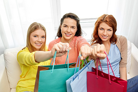 消费主义,友谊生活方式的三个微笑的十几岁女孩朋友带着购物袋家十几岁的女孩家带购物袋图片