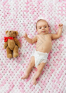 婴儿期人们的甜蜜的小女孩尿布上躺着,毛绒纱的针毛毯毛绒纱穿着尿布的女婴泰迪躺毯子上图片
