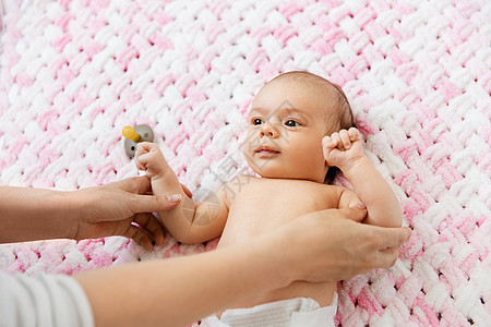 婴儿期,母亲人的母亲的手可爱的小女儿躺针的粉红色毛毯的毛绒纱可爱的女婴躺针毛绒毯上图片