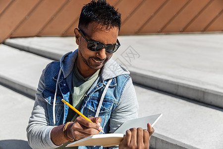 休闲,文学人的印度男子与笔记本,日记素描本写作画屋顶上屋顶上笔记本素描本的印度男人图片