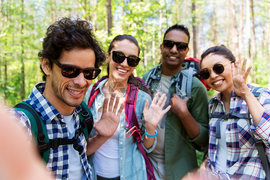 旅行,旅游,徒步旅行人的群朋友带着背包森林里自拍挥手朋友们带着背包徒步旅行自拍图片