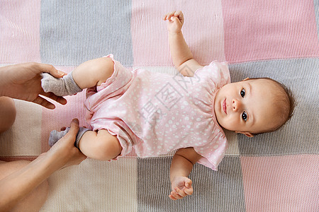 婴儿期,母亲人的母亲的手牵着甜蜜的小女孩躺毯子上女婴躺毯子上,母亲的手图片