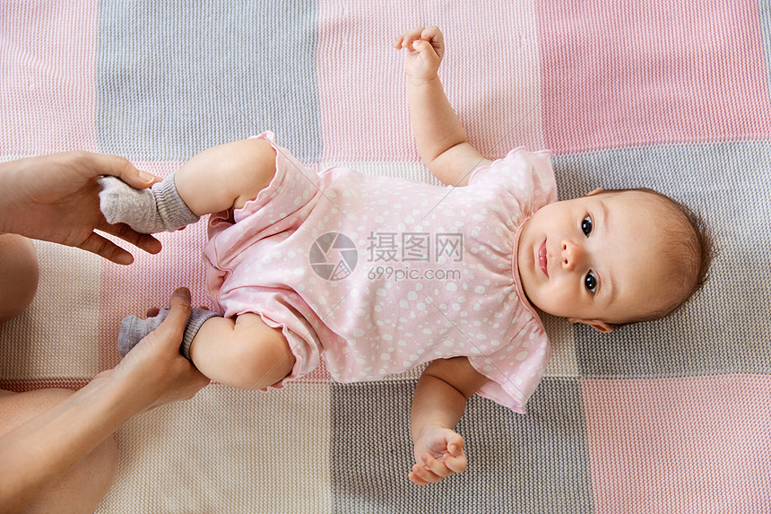 婴儿期,母亲人的母亲的手牵着甜蜜的小女孩躺毯子上女婴躺毯子上,母亲的手图片