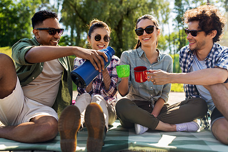 休闲,野餐人们的快乐的朋友夏季公园的室外热水瓶里喝茶快乐的朋友夏天热水瓶里喝茶图片