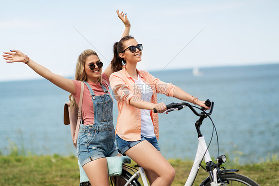 休闲友谊的快乐微笑的十几岁女孩朋友骑自行车海边夏天夏天十几岁的女孩朋友骑自行车图片